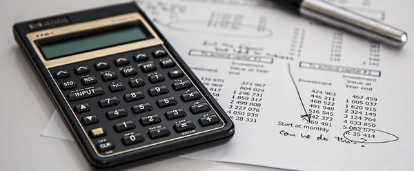 black-calculator-near-ballpoint-pen-on-white-printed-paper-53621-1