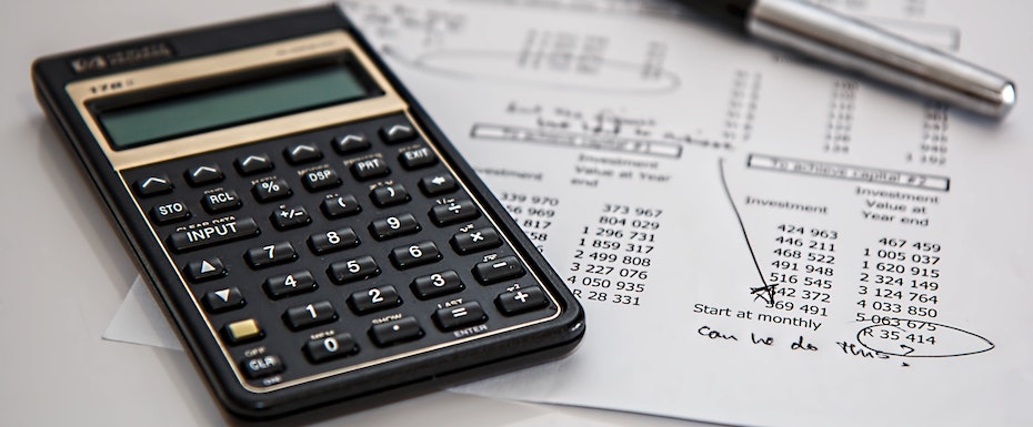 black-calculator-near-ballpoint-pen-on-white-printed-paper-53621-1